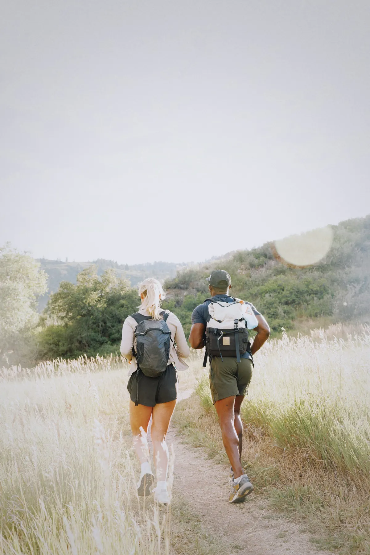 Couple hiking together on a sunny trail